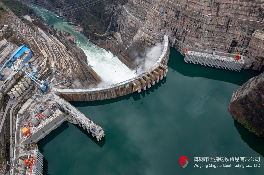 10月24日下午，白鶴灘水電站右岸地下廠房最后一倉封頂混凝土澆筑完成，標志著世界在建最大水電站地下廠房全線封頂。在該工程建設中，河鋼集團舞鋼公司累計生產供應Q500、Q345C/B、SX780等數個新品種鋼板4500噸，主要用于水電站水輪機座環、發電機頂蓋、控制環、壓力鋼管制造，大大加速了大型發電機組用鋼國產化進程。    據介紹，白鶴灘水電站位于四川省涼山州和云南省昭通市交界處，是世界在建規模最大的水電工程，裝機總容量1600萬千瓦，其左右岸地下廠房內分別布置8臺具有完全自主知識產權的單機容量達100萬千瓦的水輪發電機組，單機容量位居世界第一。10月24日下午，白鶴灘水電站成功蓄水至825米高程，首次達到正常水位，大壩將接受高水位全面檢驗。    該工程的規模天然決定了其施工難度極高，復雜的地形地質條件和技術指標等因素也給施工帶來了巨大挑戰。因此在電站建設材料及關鍵部位用鋼的選擇上，客戶慎之又慎，對焊接性能、韌性、強度等均有著極為嚴苛的技術要求。舞鋼公司憑借強大的質量品牌優勢和雄厚的技術實力成功中標——數百噸“舞鋼牌”高技術含量的大厚度高級別水電鋼板用于制造世界單機容量最大的巨型水輪發電機組的座環。    隨后，舞鋼公司為白鶴灘水電站定制研發265mm厚的SXQ500D-Z35鋼板，并進一步制作加工件。公司科技部高強鋼研究所針對該鋼的生產重點和難點，提前制定措施，并在冶煉、制坯等關鍵環節派人進行跟蹤、協調。在科技、設備、生產人員的共同努力下，該批鋼板最終順利生產完畢。鋼板及試樣經公司、客戶和第三方檢驗機構檢驗合格后，在三和盛機建公司完成切割深加工。    交付客戶后，該鋼憑著焊接性能好、力學結構良好、低溫沖擊韌性強等優點，承受住了巨大的水壓力和沖擊負荷，再次贏得設備制造方的高度評價。（舞鋼市委宣傳部 楊德坤 張培軍）